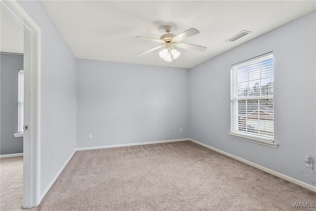 carpeted empty room with a textured ceiling and ceiling fan