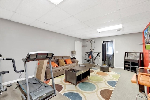 exercise area featuring light carpet and a paneled ceiling