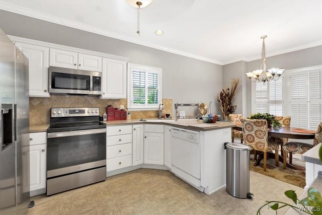 kitchen featuring decorative light fixtures, white cabinets, appliances with stainless steel finishes, and sink