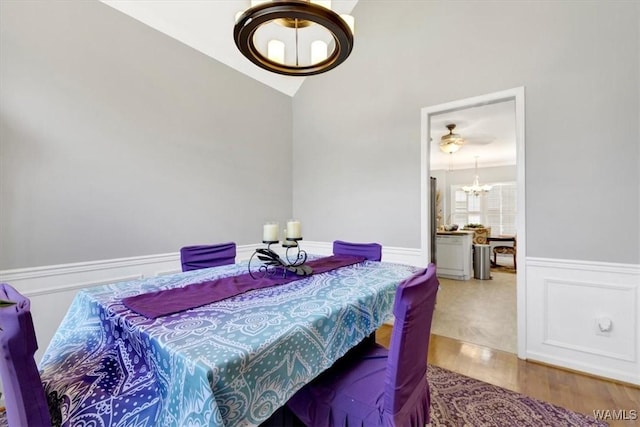 dining space featuring hardwood / wood-style flooring, lofted ceiling, and a chandelier