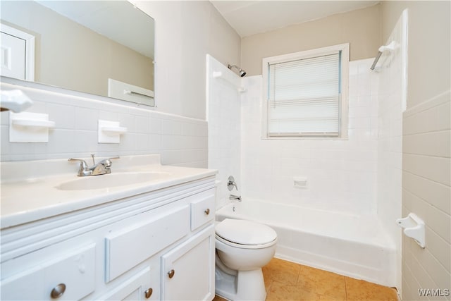 full bathroom featuring tile patterned flooring, tiled shower / bath combo, tile walls, and vanity