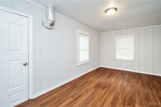 spare room featuring dark hardwood / wood-style flooring and ornamental molding