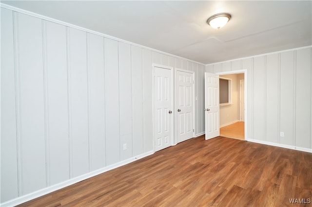 unfurnished bedroom with hardwood / wood-style flooring and crown molding