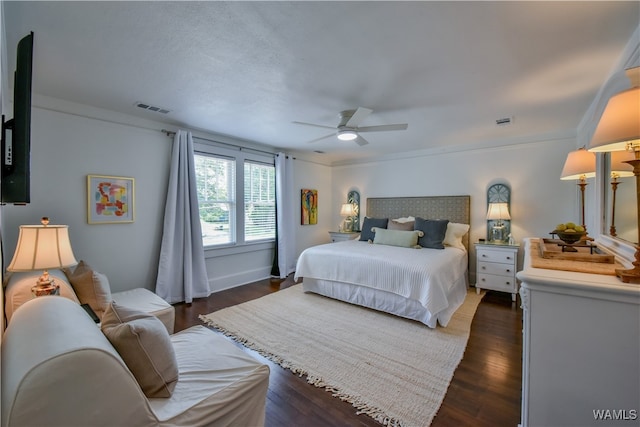 bedroom with ceiling fan, crown molding, and dark wood-type flooring