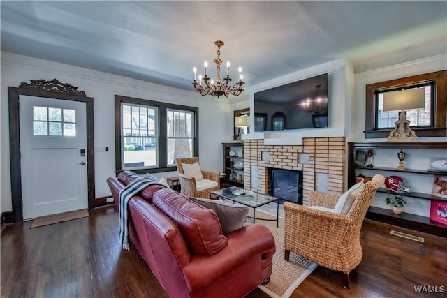 living room with a chandelier, dark hardwood / wood-style floors, a fireplace, and ornamental molding