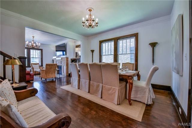 dining space featuring a notable chandelier, dark hardwood / wood-style floors, and ornamental molding