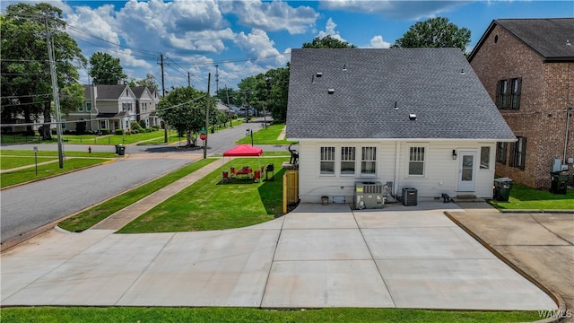 rear view of property with a yard and central AC