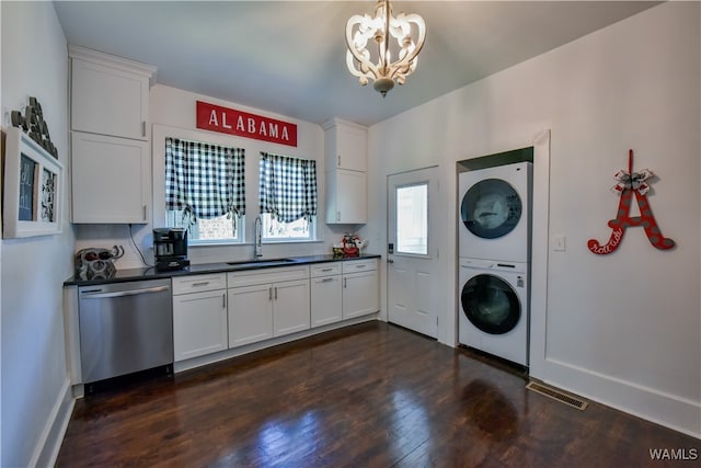 laundry area with dark hardwood / wood-style flooring, an inviting chandelier, stacked washer and clothes dryer, and sink