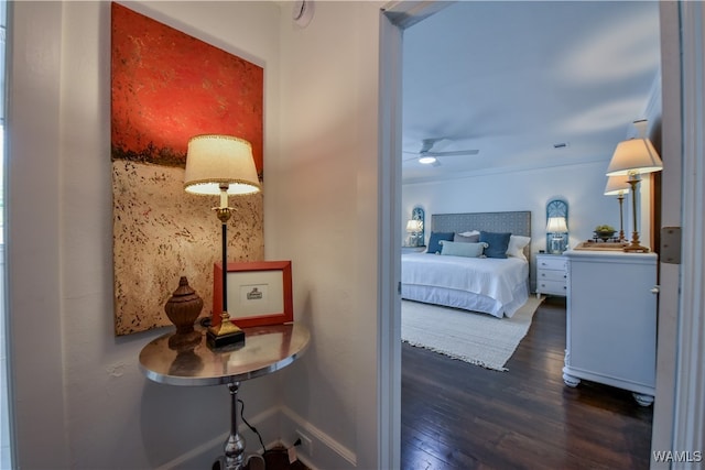 bedroom featuring dark hardwood / wood-style flooring, ceiling fan, and crown molding