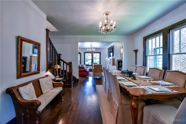 dining room with ornamental molding, dark wood-type flooring, a wealth of natural light, and a chandelier