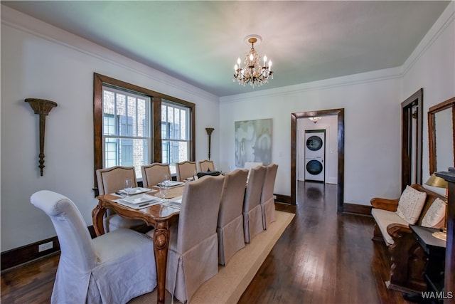 dining area with crown molding, dark hardwood / wood-style flooring, stacked washer / dryer, and a chandelier