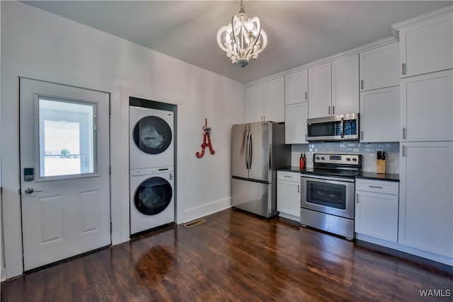 kitchen featuring dark hardwood / wood-style flooring, white cabinetry, stacked washer and dryer, and stainless steel appliances