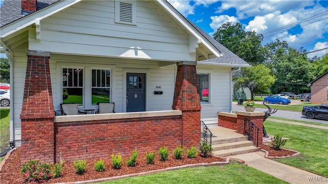 bungalow-style house with a front lawn and a porch