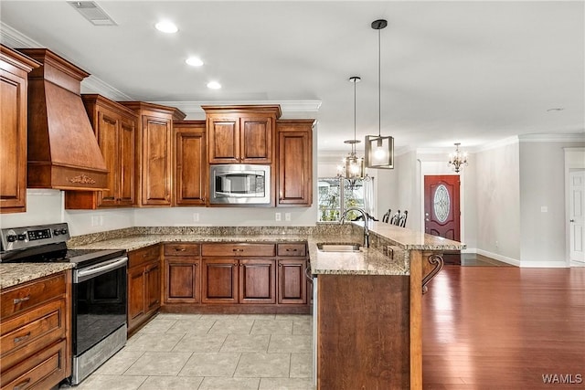 kitchen with custom exhaust hood, stainless steel appliances, sink, pendant lighting, and light hardwood / wood-style floors