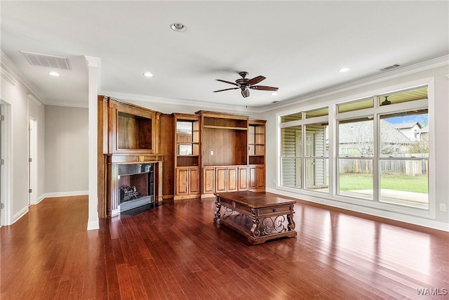 unfurnished living room featuring dark hardwood / wood-style floors, a fireplace, crown molding, and ceiling fan