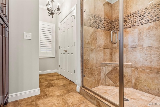 bathroom with an inviting chandelier, walk in shower, and ornamental molding