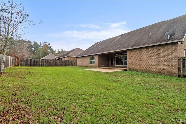 rear view of house featuring a lawn and a patio