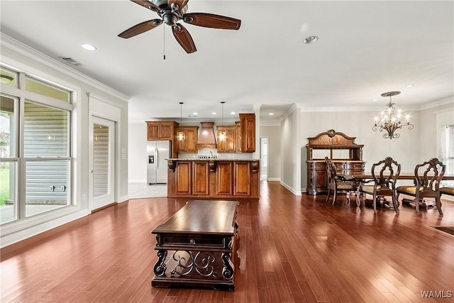 kitchen with pendant lighting, premium range hood, crown molding, dark hardwood / wood-style flooring, and stainless steel fridge with ice dispenser