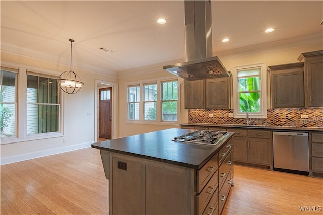 890 Founders St, Tuscaloosa, AL 35406 - kitchen featuring appliances with stainless steel finishes, island exhaust hood, dark countertops, crown molding, and decorative backsplash