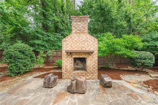 890 Founders St, Tuscaloosa, AL 35406 - fenced backyard with an outdoor brick fireplace and a patio area