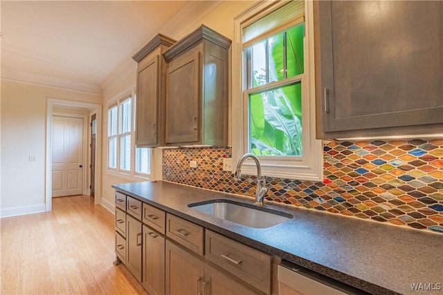 890 Founders St, Tuscaloosa, AL 35406 - kitchen with dark countertops, backsplash, ornamental molding, light wood-style floors, and dishwasher