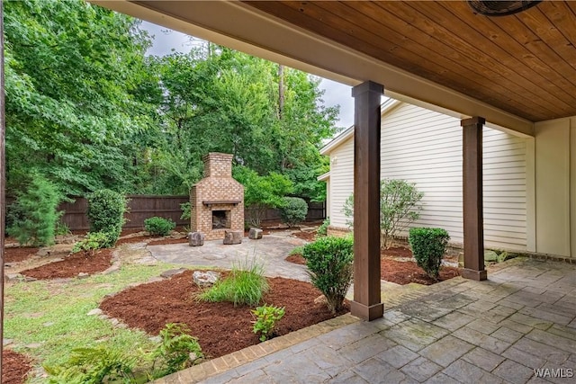890 Founders St, Tuscaloosa, AL 35406 - fenced backyard featuring an outdoor brick fireplace and a patio area