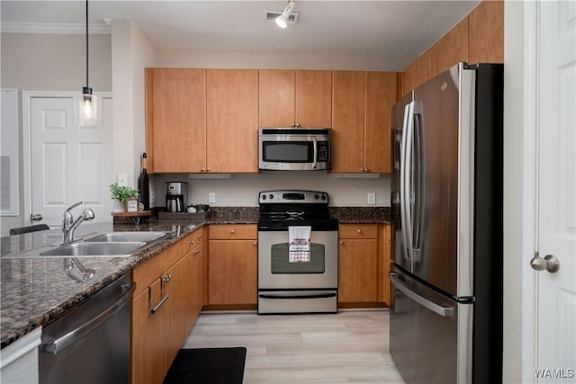 1901 5th Ave E Unit 2105, Tuscaloosa, AL 35401 - kitchen featuring stainless steel appliances, a sink, light wood-style flooring, dark stone countertops, and pendant lighting