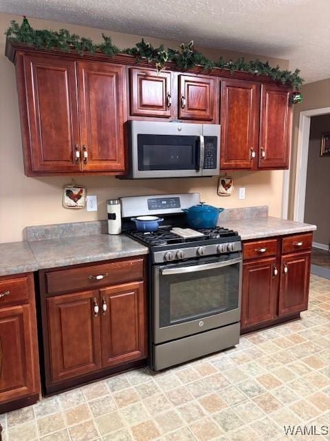 kitchen with a textured ceiling and appliances with stainless steel finishes