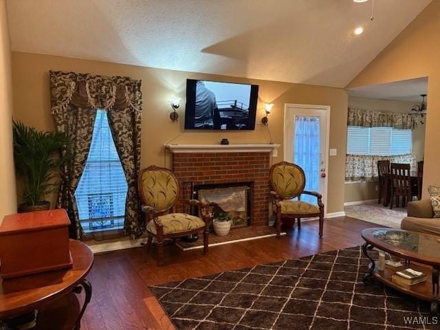 sitting room featuring lofted ceiling, a brick fireplace, and hardwood / wood-style flooring