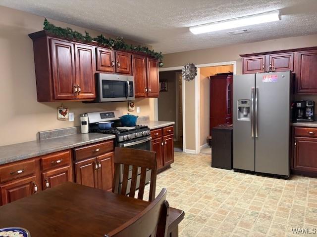 kitchen featuring stainless steel appliances and a textured ceiling