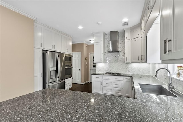 kitchen featuring a sink, appliances with stainless steel finishes, decorative backsplash, wall chimney exhaust hood, and crown molding