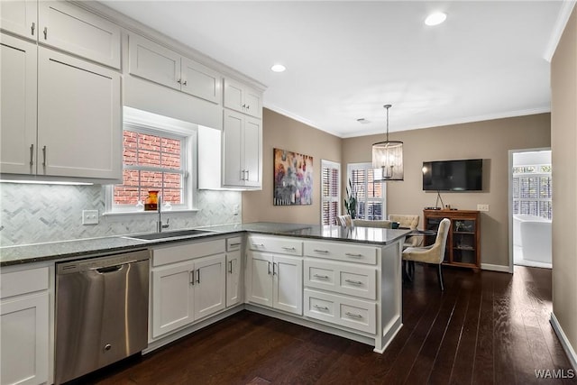 kitchen with a sink, crown molding, a peninsula, and dishwasher