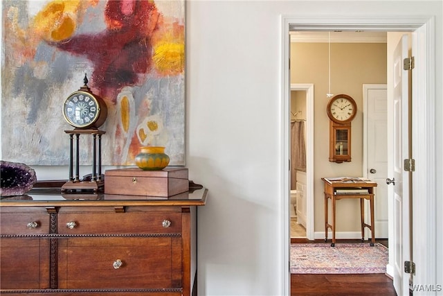 hallway featuring ornamental molding, dark wood finished floors, and baseboards