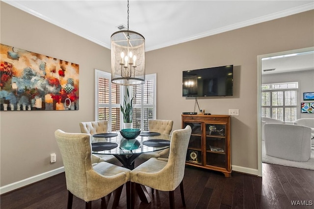 dining room featuring a notable chandelier, wood-type flooring, baseboards, and crown molding