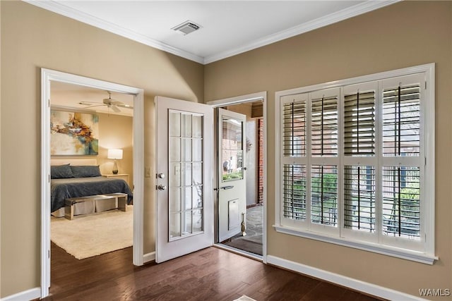 foyer featuring baseboards, visible vents, dark wood-type flooring, and ornamental molding