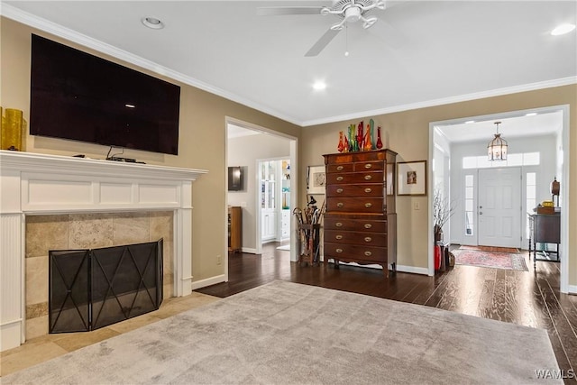 living room featuring ornamental molding, a fireplace, wood finished floors, and baseboards