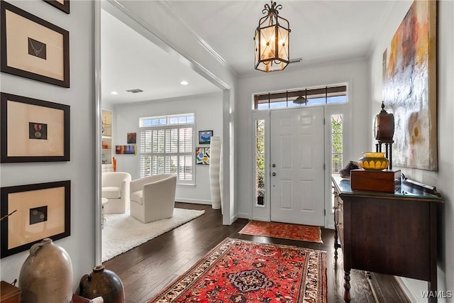 foyer with baseboards, visible vents, ornamental molding, dark wood-type flooring, and recessed lighting