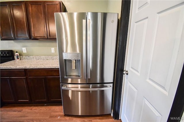 kitchen featuring stainless steel fridge, dark brown cabinets, black electric range oven, and dark wood-type flooring