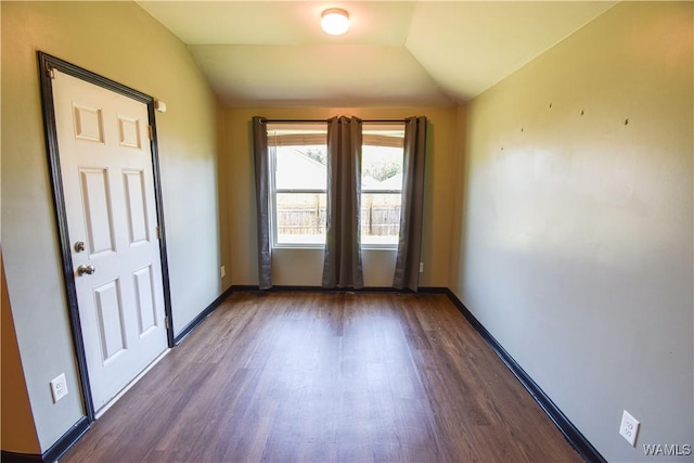 empty room with dark wood-type flooring and vaulted ceiling