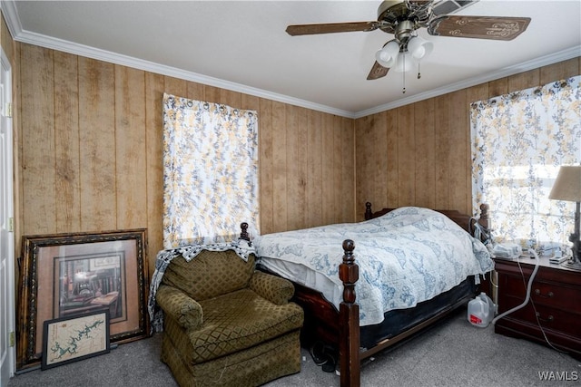 carpeted bedroom featuring ceiling fan, ornamental molding, and wooden walls