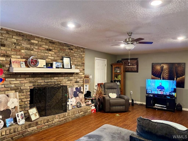 living area featuring dark wood-style floors, ceiling fan, a textured ceiling, and baseboards