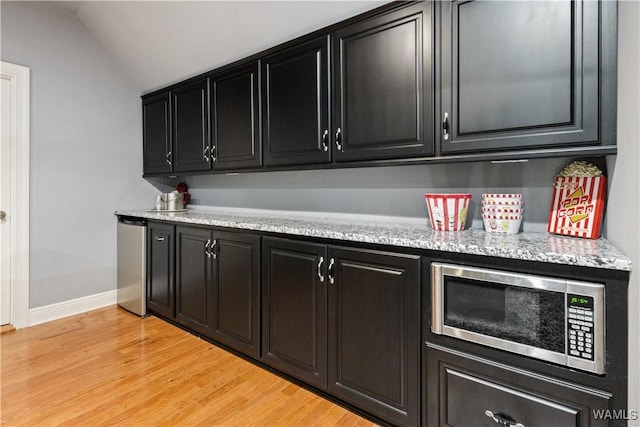 3610 Harbor Ridge Way, Tuscaloosa, AL 35406 - bar featuring stainless steel microwave, lofted ceiling, light wood-style flooring, and baseboards