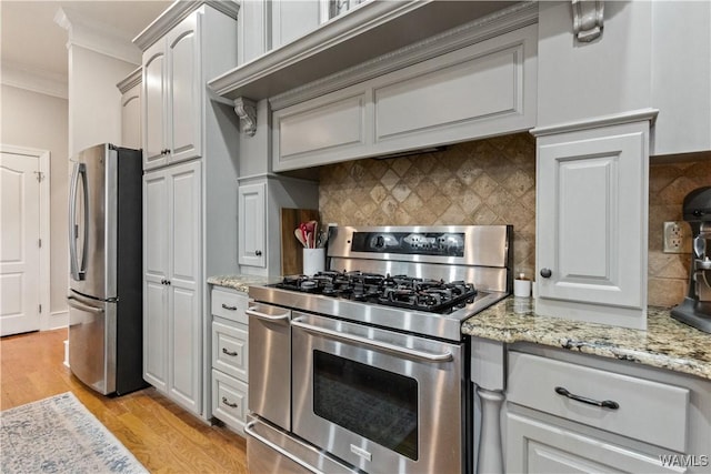 3610 Harbor Ridge Way, Tuscaloosa, AL 35406 - kitchen with appliances with stainless steel finishes, crown molding, light wood-type flooring, tasteful backsplash, and light stone counters