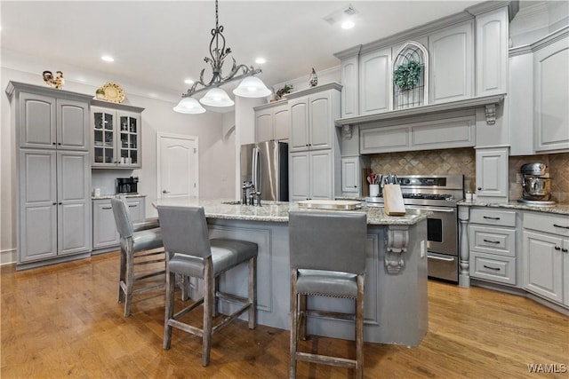 3610 Harbor Ridge Way, Tuscaloosa, AL 35406 - kitchen with stainless steel appliances, gray cabinets, a breakfast bar, backsplash, and a kitchen island with sink