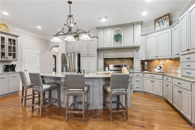 3610 Harbor Ridge Way, Tuscaloosa, AL 35406 - kitchen with stainless steel appliances, arched walkways, a kitchen breakfast bar, an island with sink, and decorative backsplash