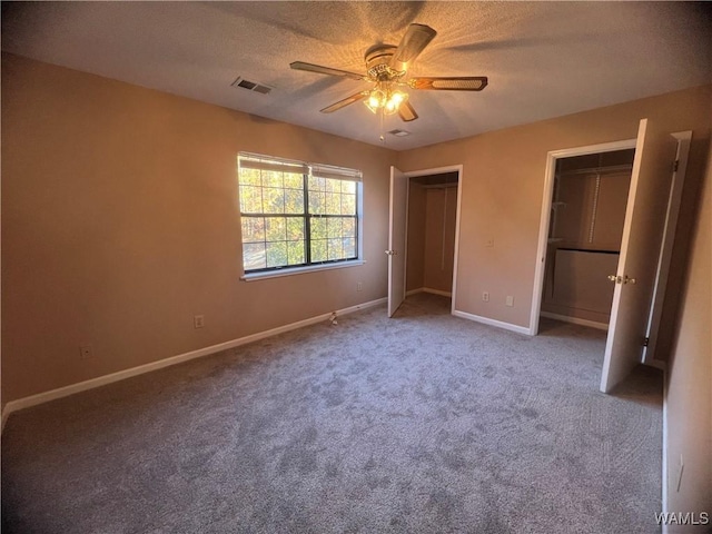 unfurnished bedroom featuring carpet flooring, a textured ceiling, and ceiling fan