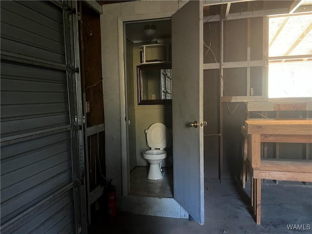 bathroom featuring concrete flooring and toilet