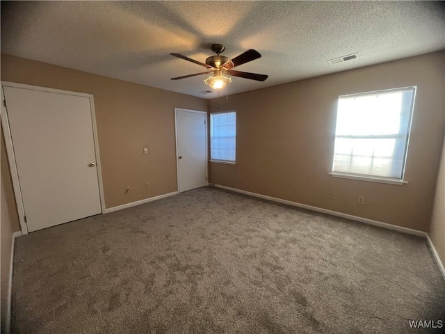 unfurnished bedroom with carpet flooring, ceiling fan, and a textured ceiling