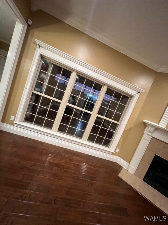 details with hardwood / wood-style flooring, crown molding, and a tile fireplace