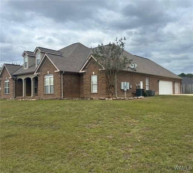 view of front facade featuring a front yard, a garage, and cooling unit